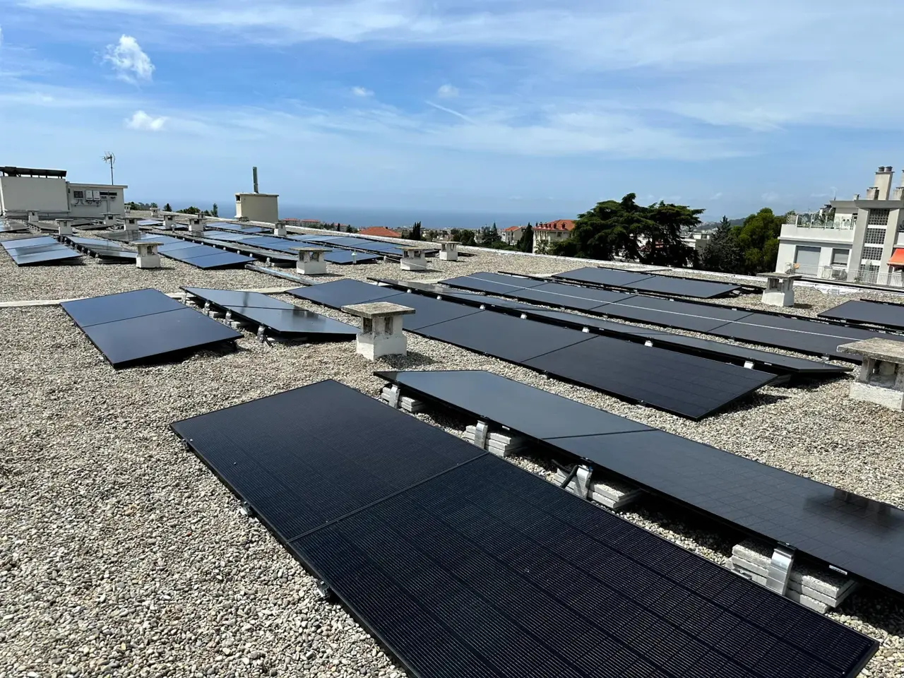 Panneaux solaires sur un toit-terrasse, vue sur les collines